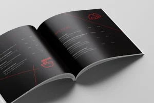 Broșură neagră deschisă, cu linii roșii și logo, design editorial